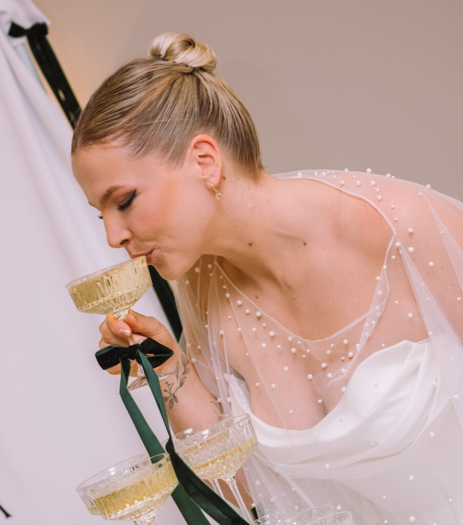 „Braut trinkt Champagner aus einem Champagne Tower während der Hochzeitsfeier in Ingolstadt.“