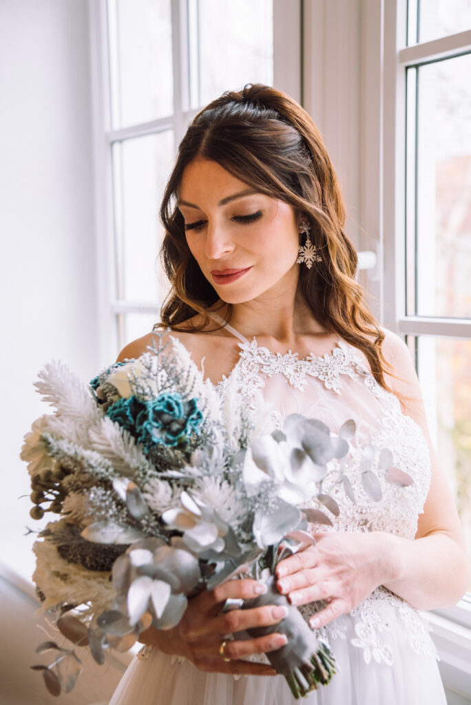 „Brautportrait mit kunstvollem Brautstrauß und eleganten Spitzenkleid bei einer Winterhochzeit in Ingolstadt.“