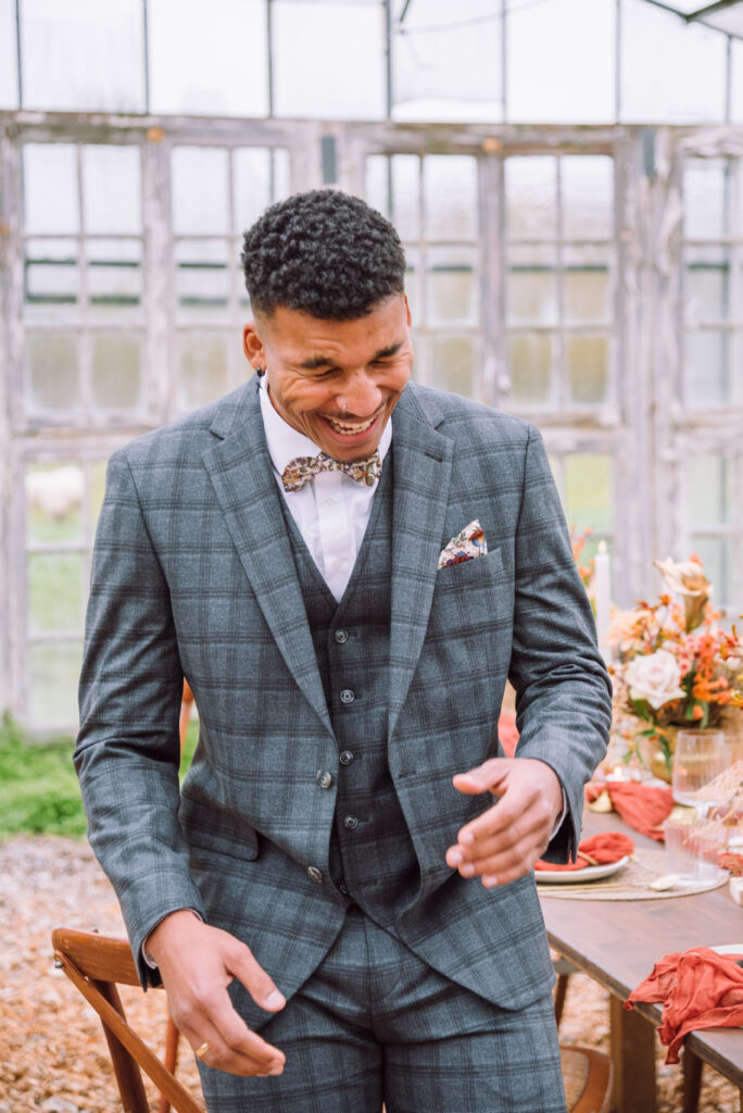 „Bräutigam im eleganten Anzug bei einer Herbsthochzeit in einem Gewächshaus – fotografiert von Hochzeitsfotografin aus Ingolstadt“
