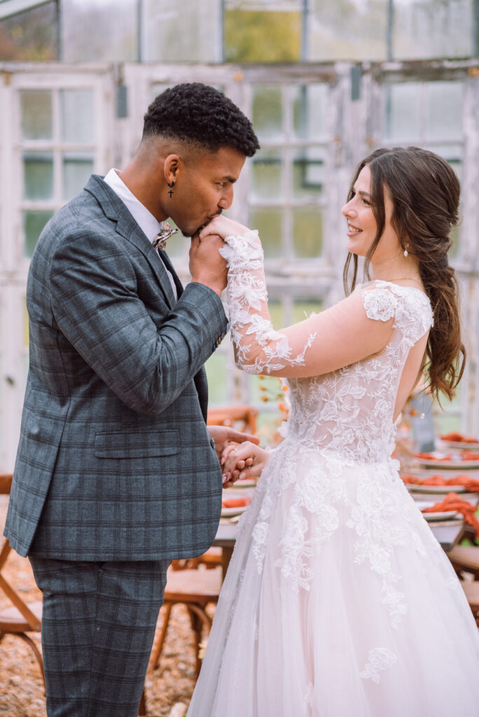 „Brautpaar bei einer romantischen Geste während einer Hochzeit in einem Gewächshaus – fotografiert von Hochzeitsfotografin aus Ingolstadt“