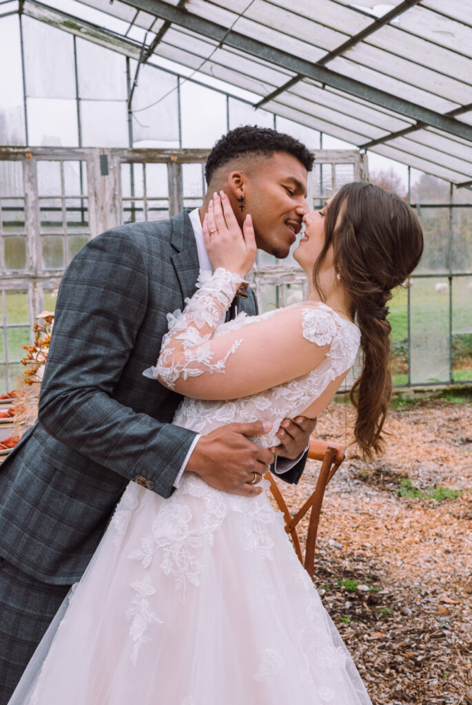 „Brautpaar bei einem Kuss während einer Herbsthochzeit in einem Gewächshaus – fotografiert von Hochzeitsfotografin aus Ingolstadt“
