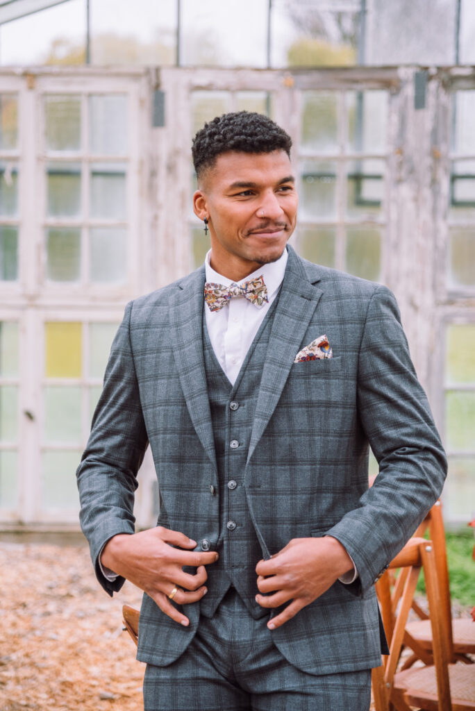 „Bräutigam in elegantem Hochzeitsanzug bei einer Herbsthochzeit in einem Gewächshaus – fotografiert von Hochzeitsfotografin aus Ingolstadt“