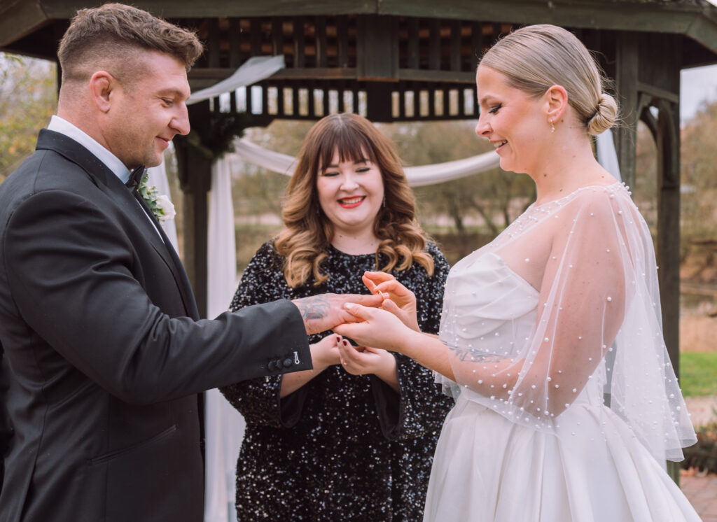 „Brautpaar beim Ringtausch während einer freien Trauung mit Traurednerin bei einer Hochzeit in Ingolstadt.“